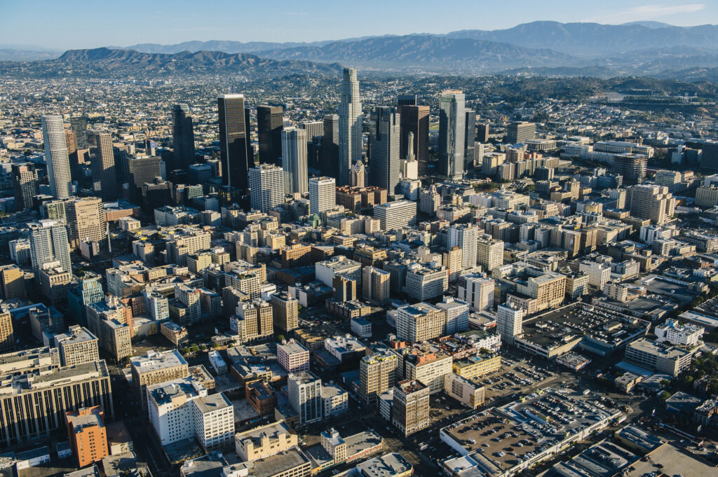 An aerial view of Los Angeles’ cityscape, with distant mountains providing a scenic background.