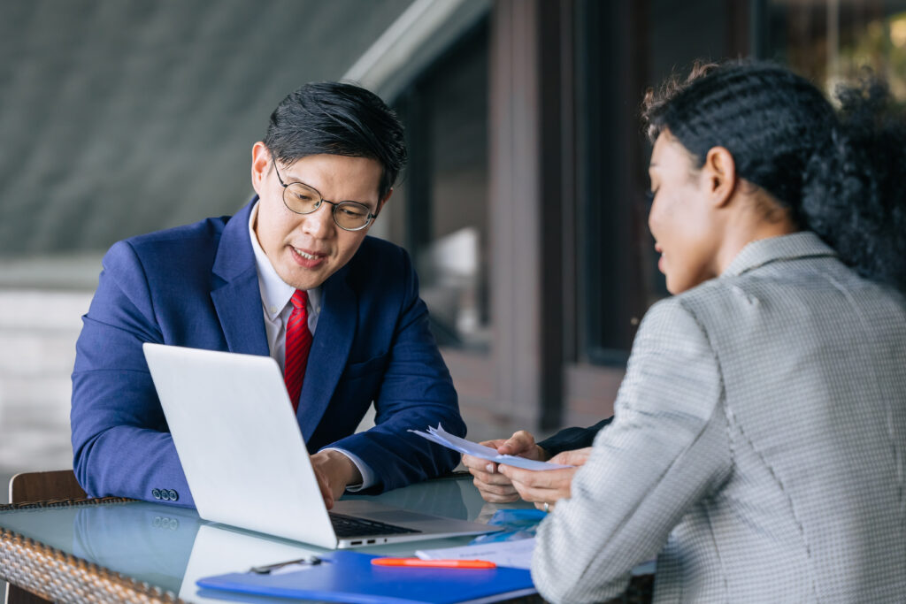 Two business professionals engaged in a discussion in a more relaxed office setting.
